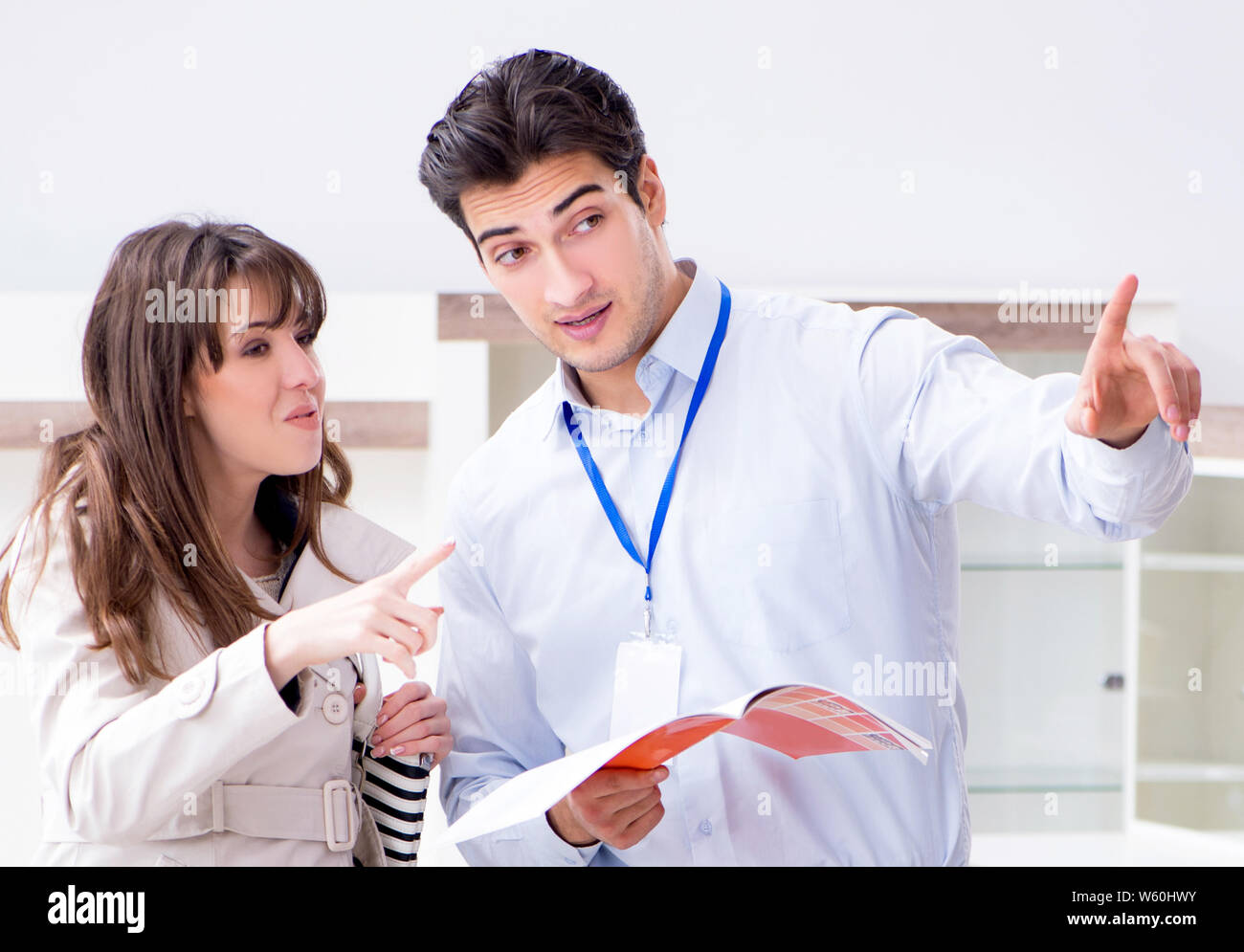 Der Verkäufer erklärt, Frau Kunde im Möbelhaus Stockfoto