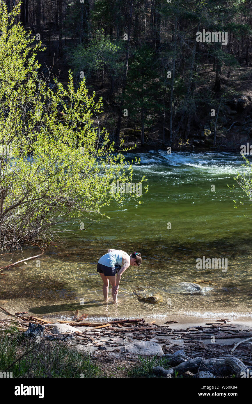 Frau waschen weg im klaren Wasser des Flusses während der sonnigen Sommertag. Stockfoto