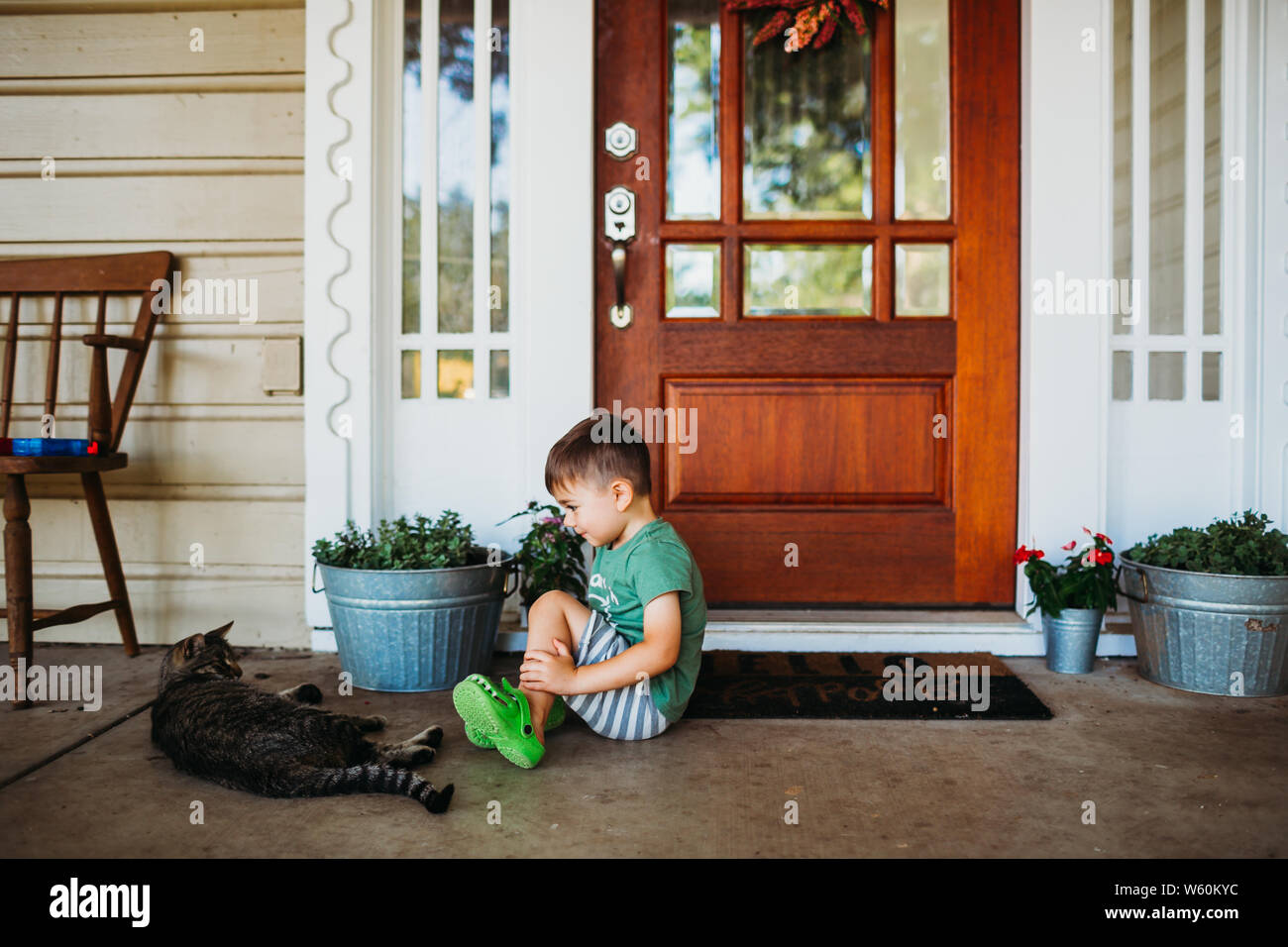 Junge mit Katze auf der Veranda im Sommer Zeit suchen Stockfoto