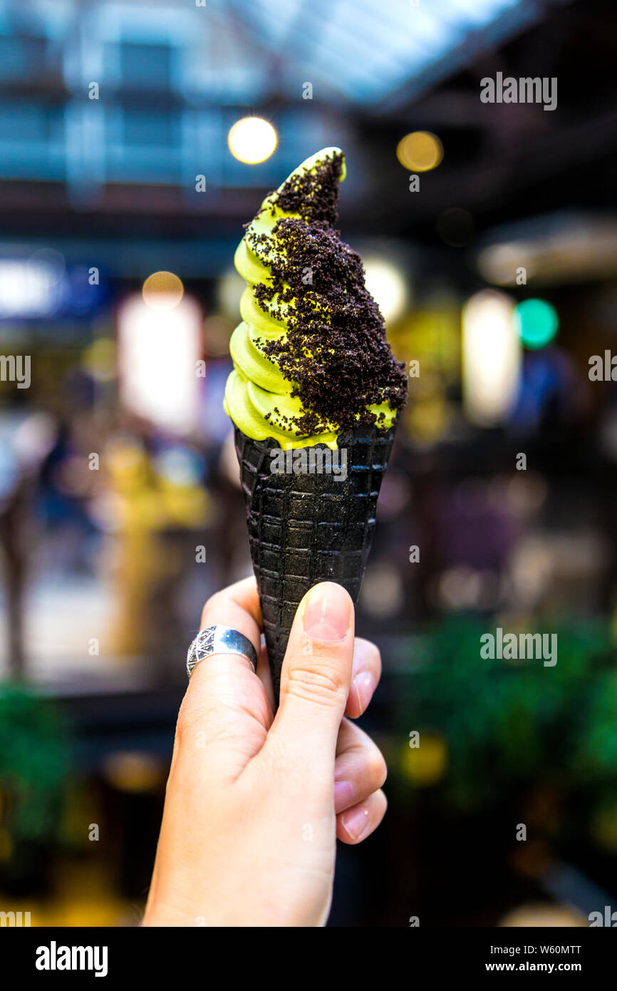 Matcha Softeis in schwarzen Kegel mit toppings in Halle, London, UK Stockfoto