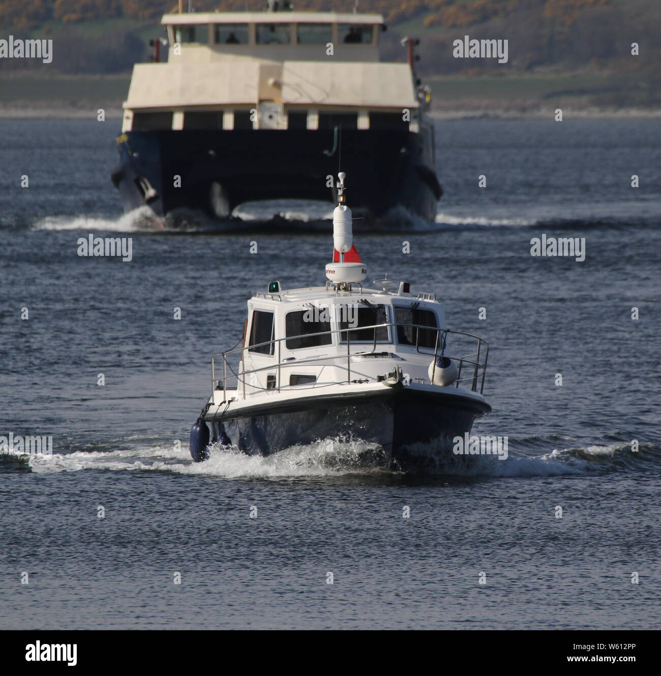 Osprey, ein privat geführtes Motor Cruiser, Ansätze von Greenock East India Hafen, mit Clyde Marine Services' Clyde Clipper hinter. Stockfoto
