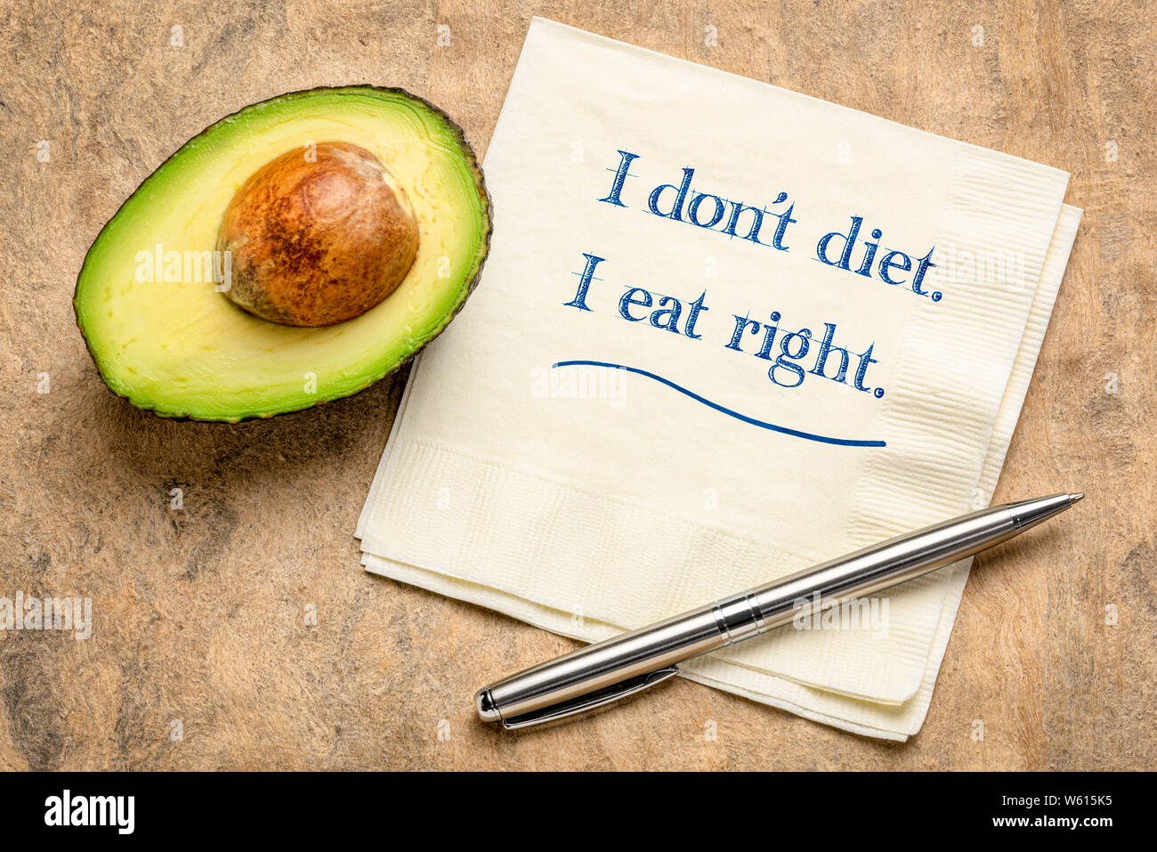 Ich glaube nicht, Ernährung, ich esse Recht - inspirational Schreiben auf eine Serviette mit einem Schnitt Avocado. Stockfoto