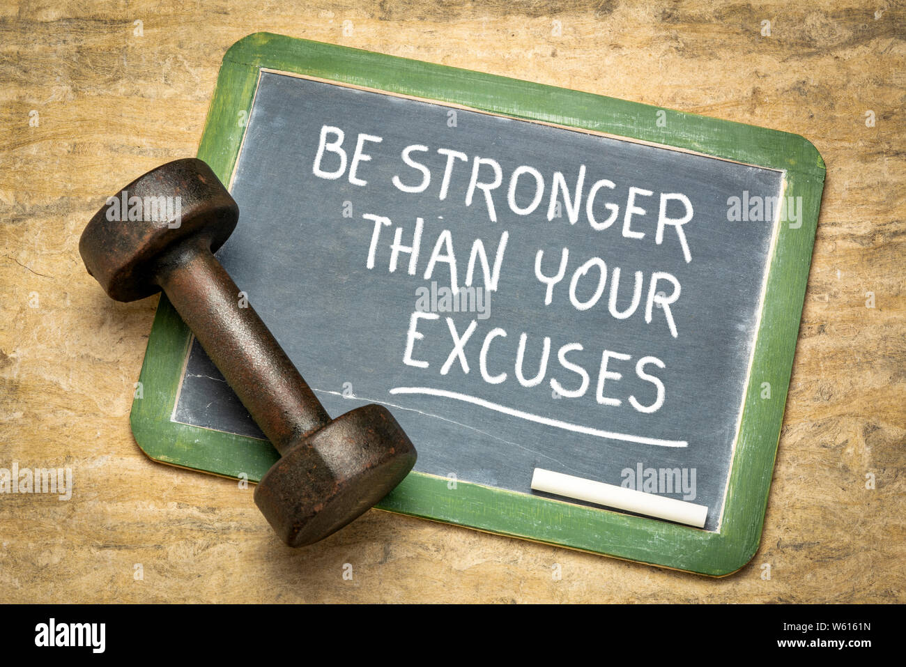 Stärker als ihre Entschuldigungen - Fitness motivation Zitat auf einem Schiefer Tafel mit einem Eisen Hantel Stockfoto