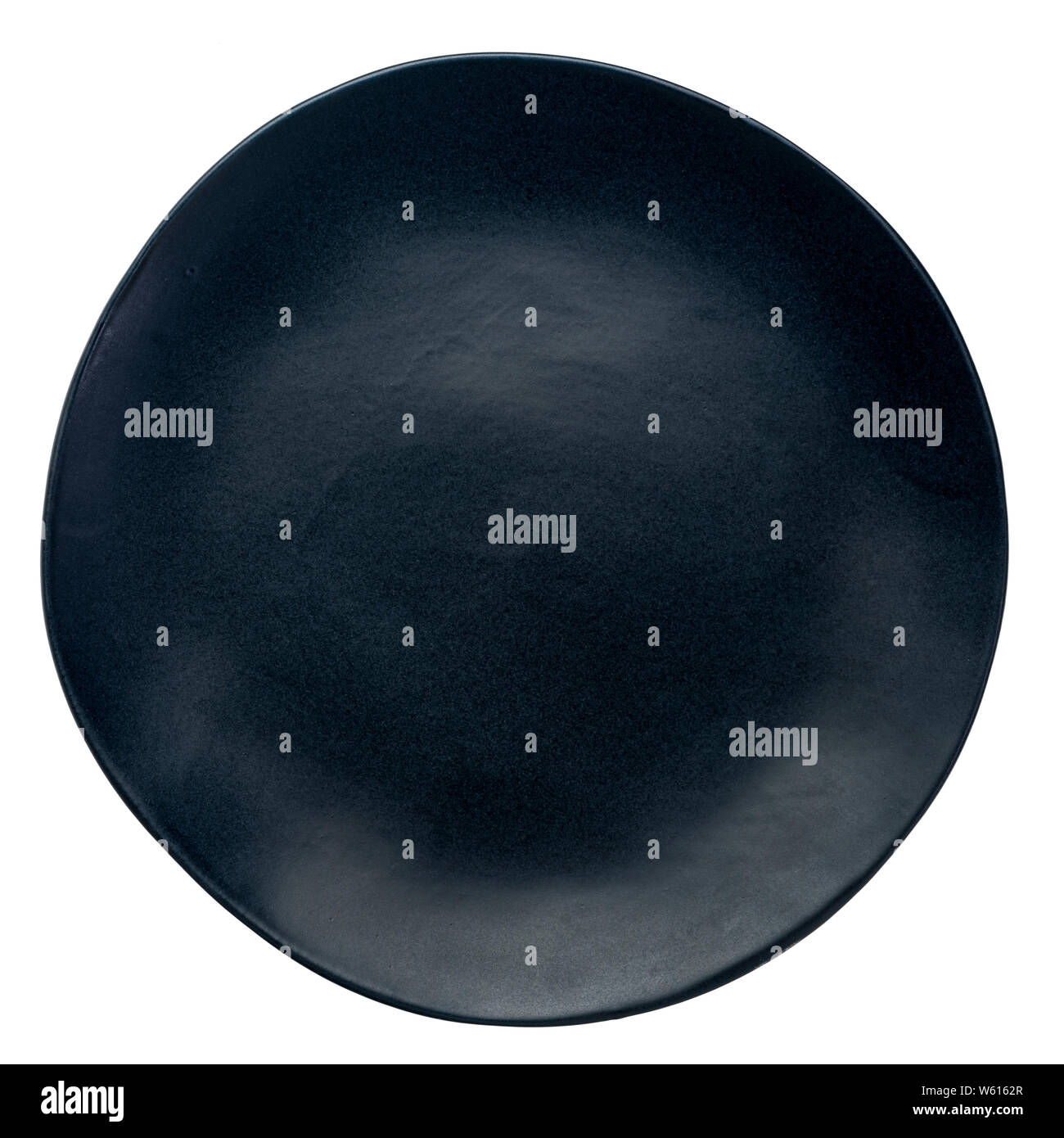 Leere schwarze Keramikplatte mit einer unregelmäßigen Rand isoliert auf weißem Stockfoto
