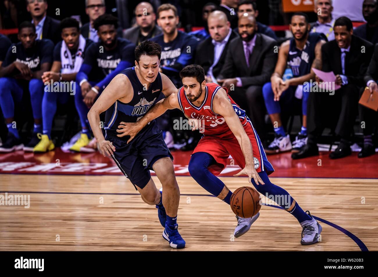 Ding Yanyuhang der Dallas Mavericks, Links, Herausforderungen Furkan Korkmaz von Philadelphia 76ers bei der Shenzhen Spiel der NBA China Spiele in Shenzhe Stockfoto
