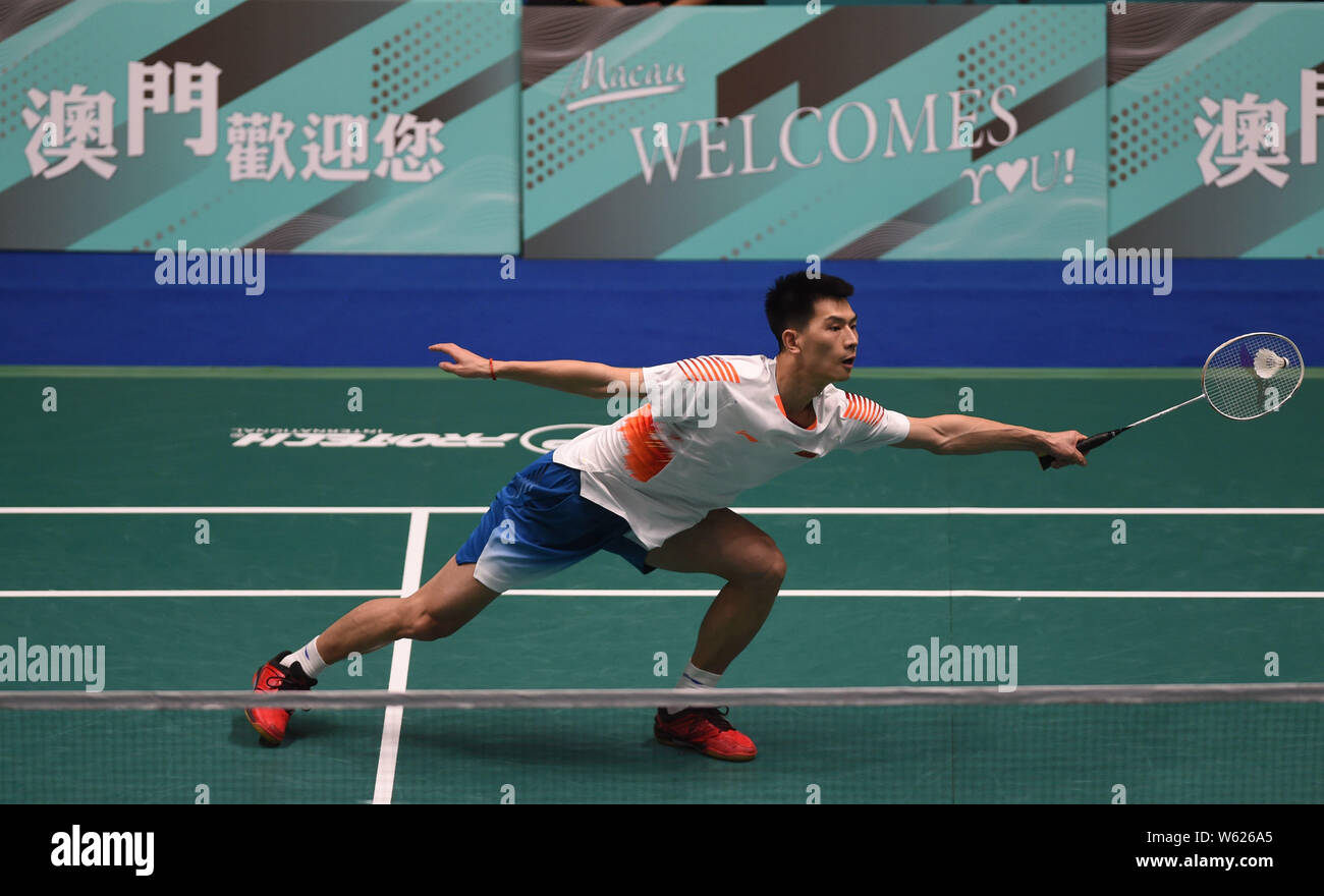 Zhao Junpeng China liefert einen Schuß zu Sony Dwi Kuncoro von Indonesien in der ersten Runde von Singles Männer während der HSBC BWF World Tour Macau Stockfoto