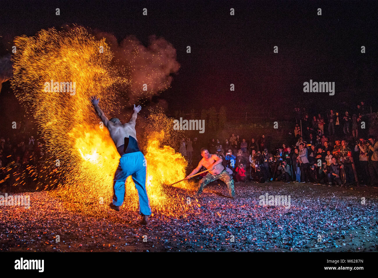 Chinesische Dorfbewohner Spaziergang durch Köhlerei, wie er in der traditionellen Ritual "Lianhuo' oder 'Fire walking' teilnimmt, in der Pan'an county, Jinhua ci Stockfoto