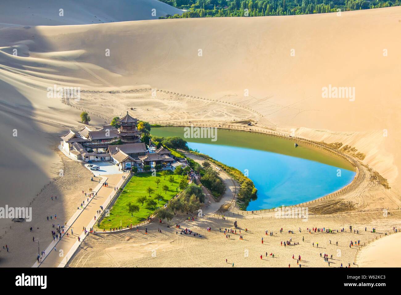 Blick auf den Crescent Moon Lake, auch als Singing-Sand Yueyaquan, durch die Dünen in der Wüste Gobi in Dunhuang, Nordwesten Chinas Gansu umgeben bekannt Stockfoto