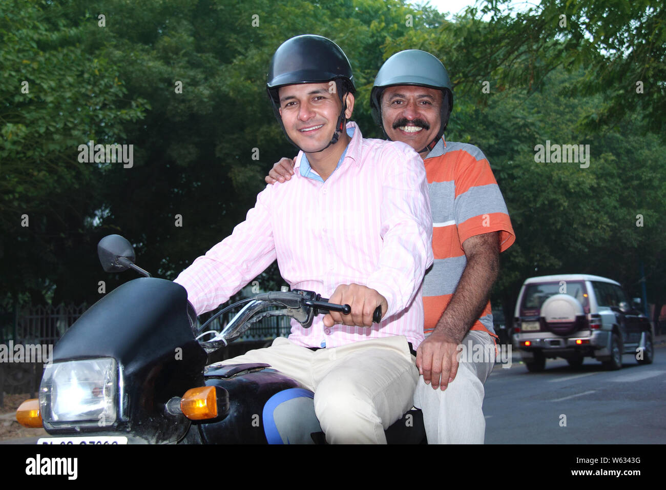 Mann mit seinem Motorrad auf der Straße Vater Stockfoto