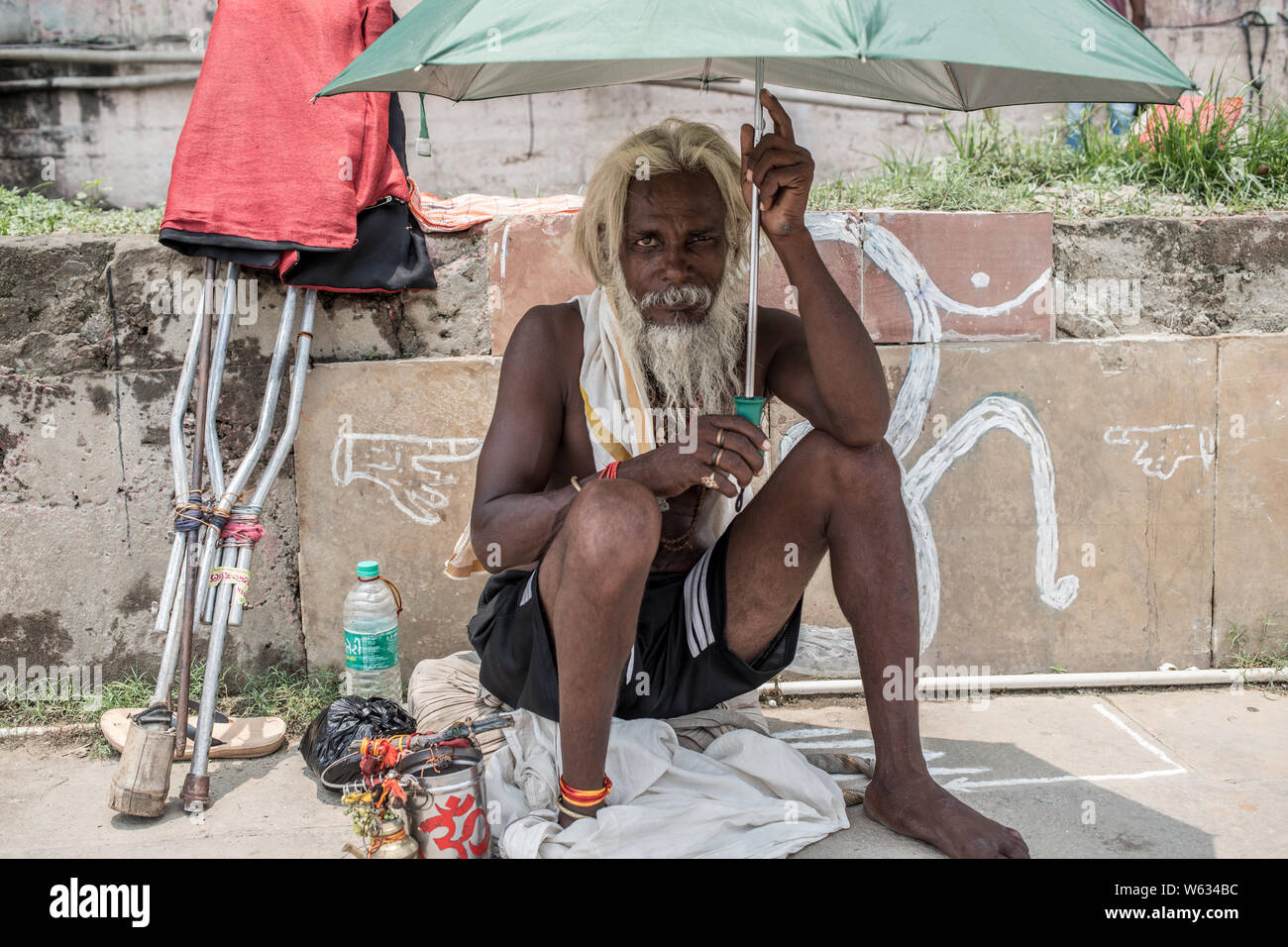 Eine obdachlose Bettler von der Straße in Varanasi, Indien sitzen Stockfoto