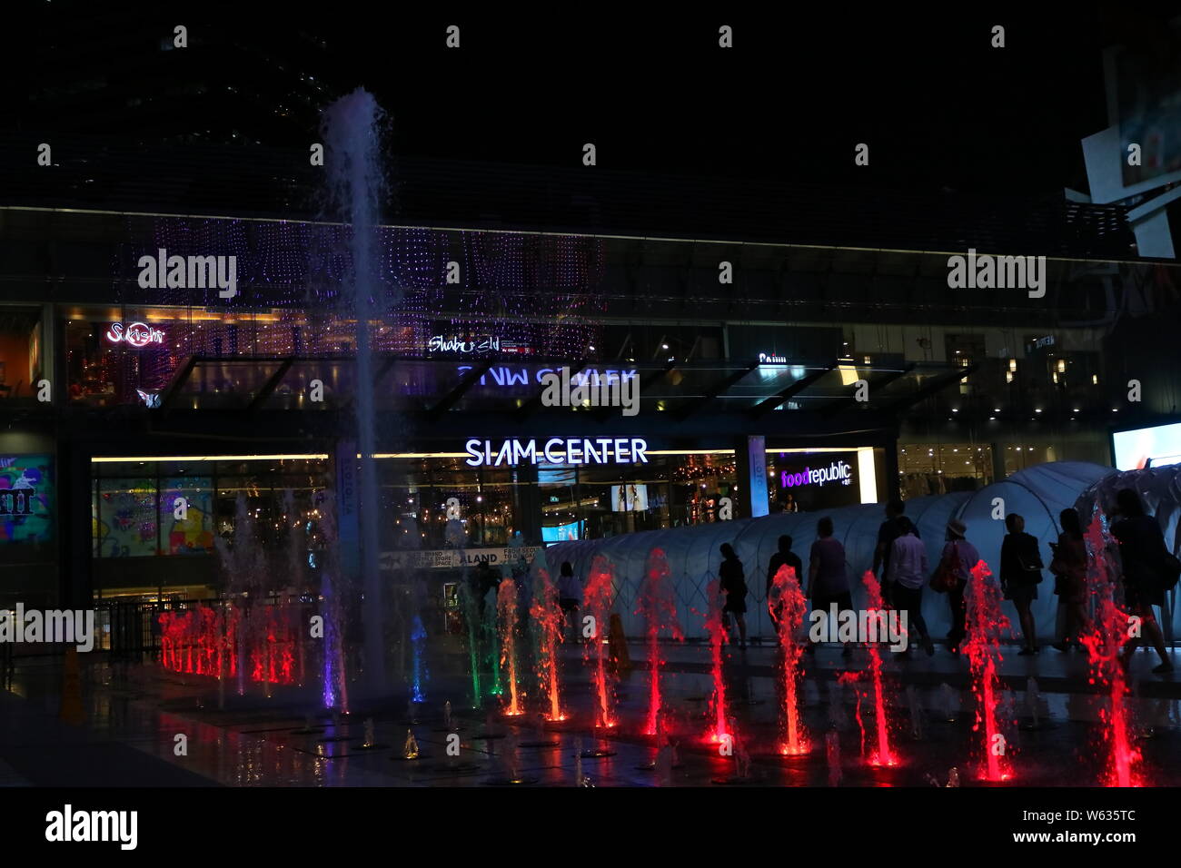 Wasserspiele vor Siam Center und Siam Paragon Shopping Mall in der Nacht. Sie sind berühmte Einkaufszentrum in Bangkok, Thailand. Stockfoto