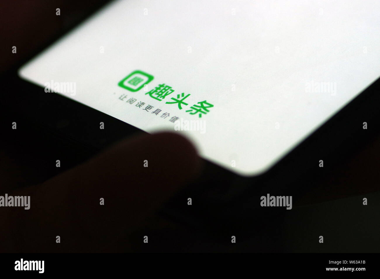---- Eine chinesische Mobiltelefon Benutzer verwendet, News und video Aggregation app Qutoutiao auf seinem Smartphone in Ji'nan City's East China Shandong prov Stockfoto
