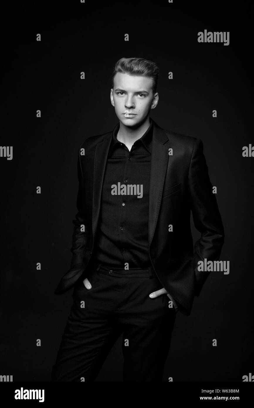 Junge Mann in Schwarz Jacke auf schwarzem Hintergrund, Schwarz und Weiß Foto Stockfoto