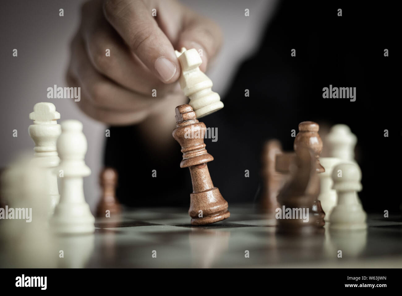 Nahaufnahme der Hand des Business woman Spielen auf dem Schachbrett durch das Töten der König des Gegners Metapher business Wettbewerb Gewinner und Verlierer sel zu gewinnen. Stockfoto