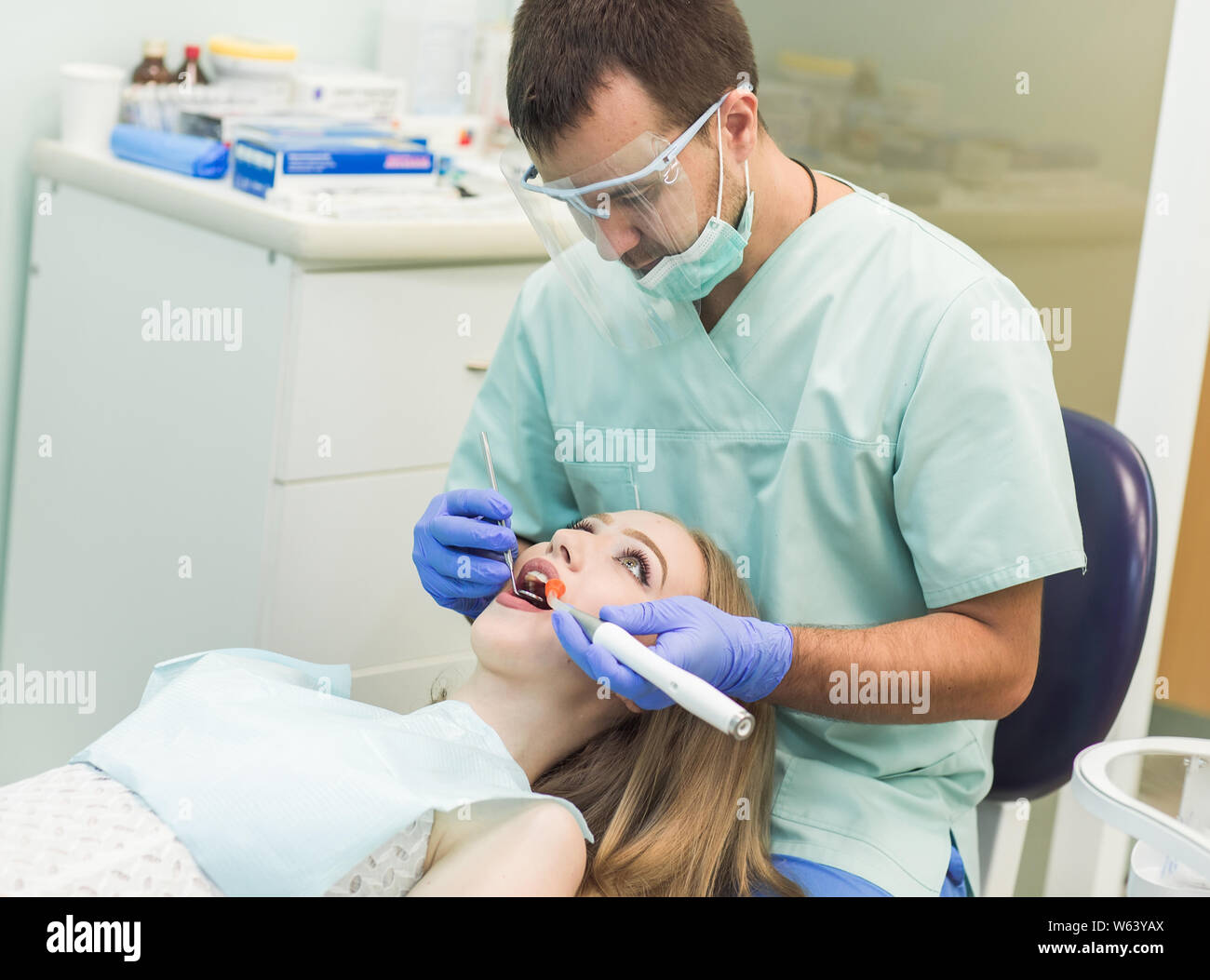 Zahnarzt tun Verfahren mit zahnmedizinischen Härtung mit UV-Licht in der Klinik Stockfoto