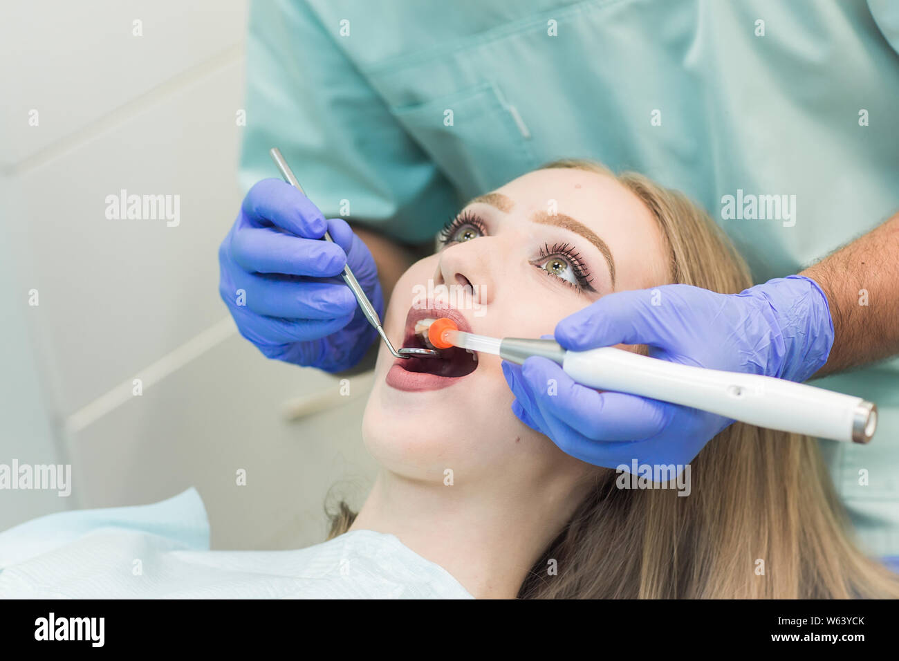 Zahnarzt tun Verfahren mit zahnmedizinischen Härtung mit UV-Licht in der Klinik Stockfoto