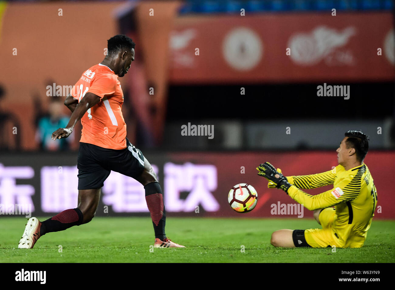 Torwart Yang Cheng, rechts, Hebei China Fortune speichert das Schießen von senegalesischer Fußballspieler Makhete Diop von Peking Renhe in der 22. Runde Stockfoto