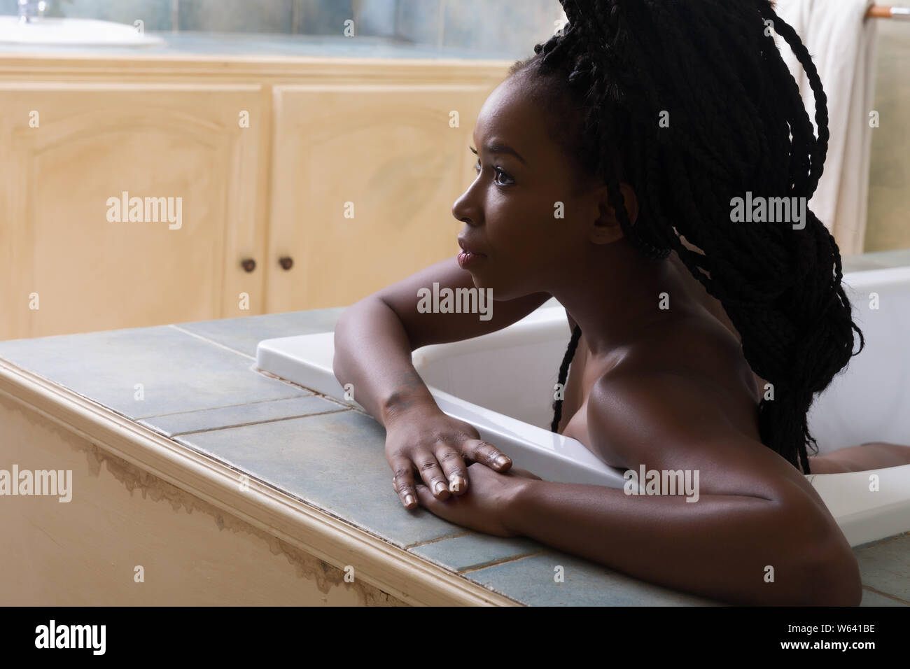 Schöne Frau mit afro Haar träumen in Badewanne Stockfoto
