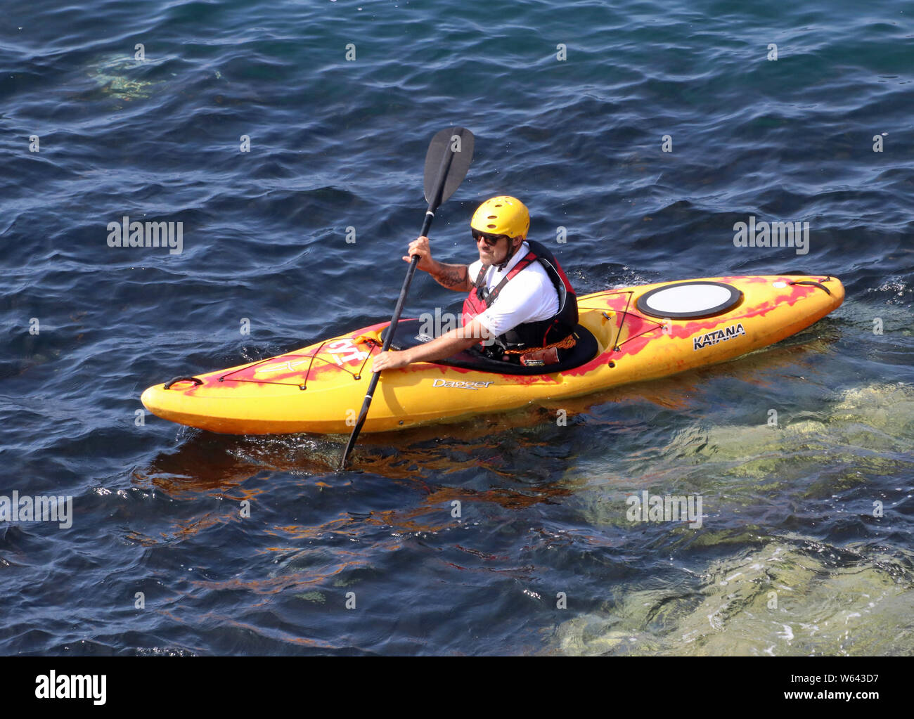 Einzelkajak in einem Plastikkajak auf dem Meer Porthclais in Pembrokshire Stockfoto