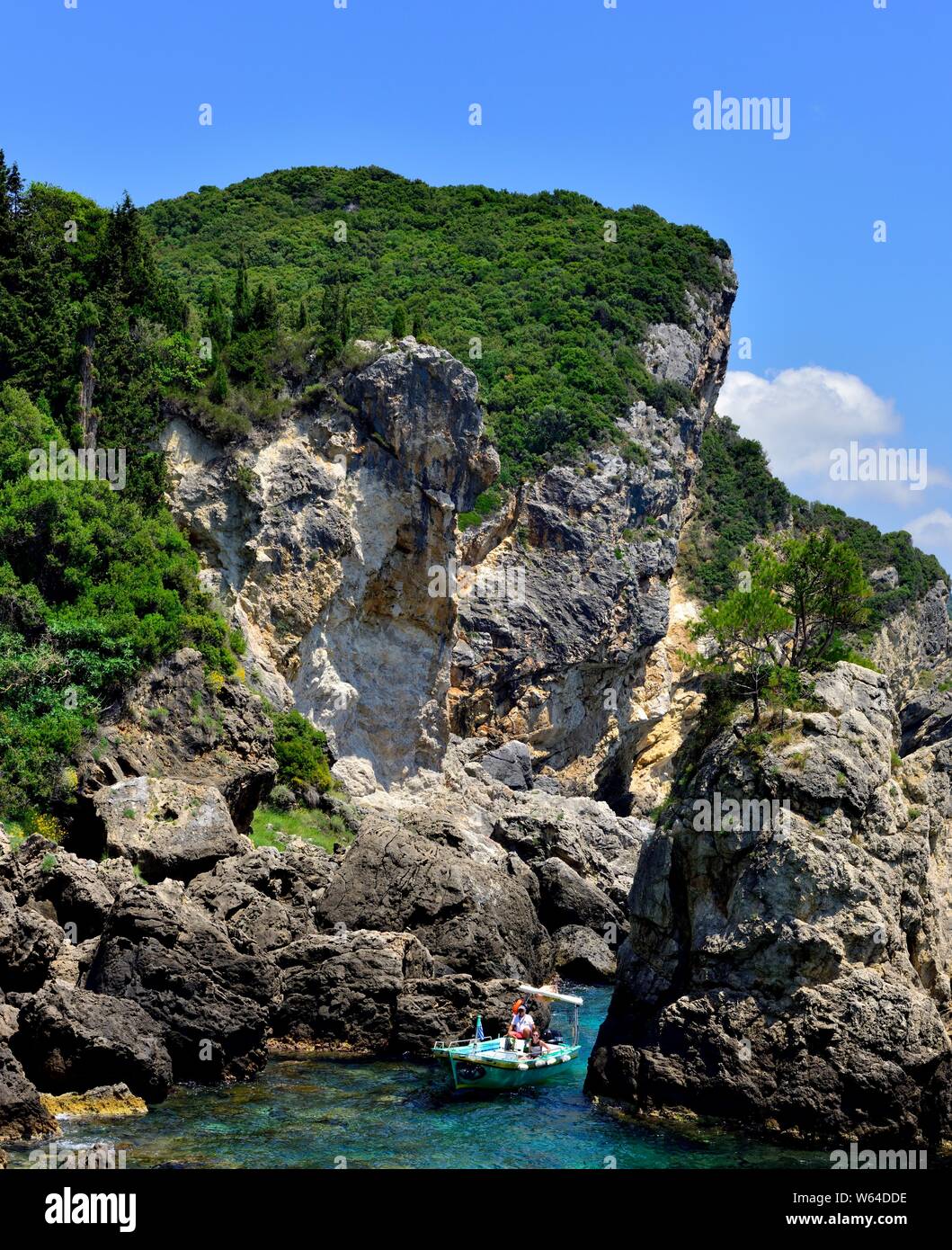 Touristenboot in einer felsigen Bucht, La Grotta Beach Bar, Paleokastritsa, Korfu, Griechenland Stockfoto