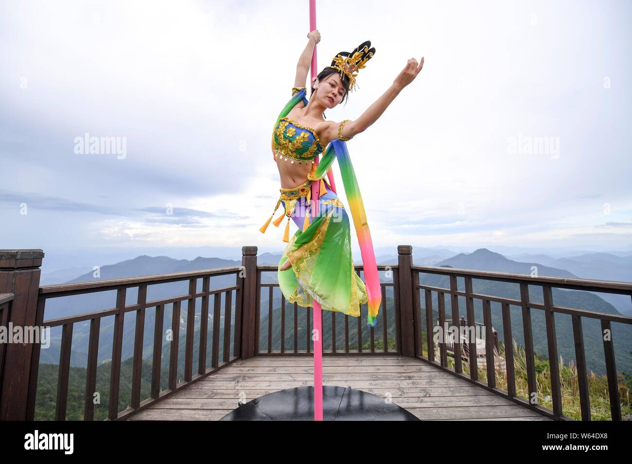 Touristen beobachten Chinesischen Enthusiasten in traditionellen Kostümen mit der Form der chinesischen Göttin des Mondes gekleidet Chang'e die Pole Dance sk Stockfoto