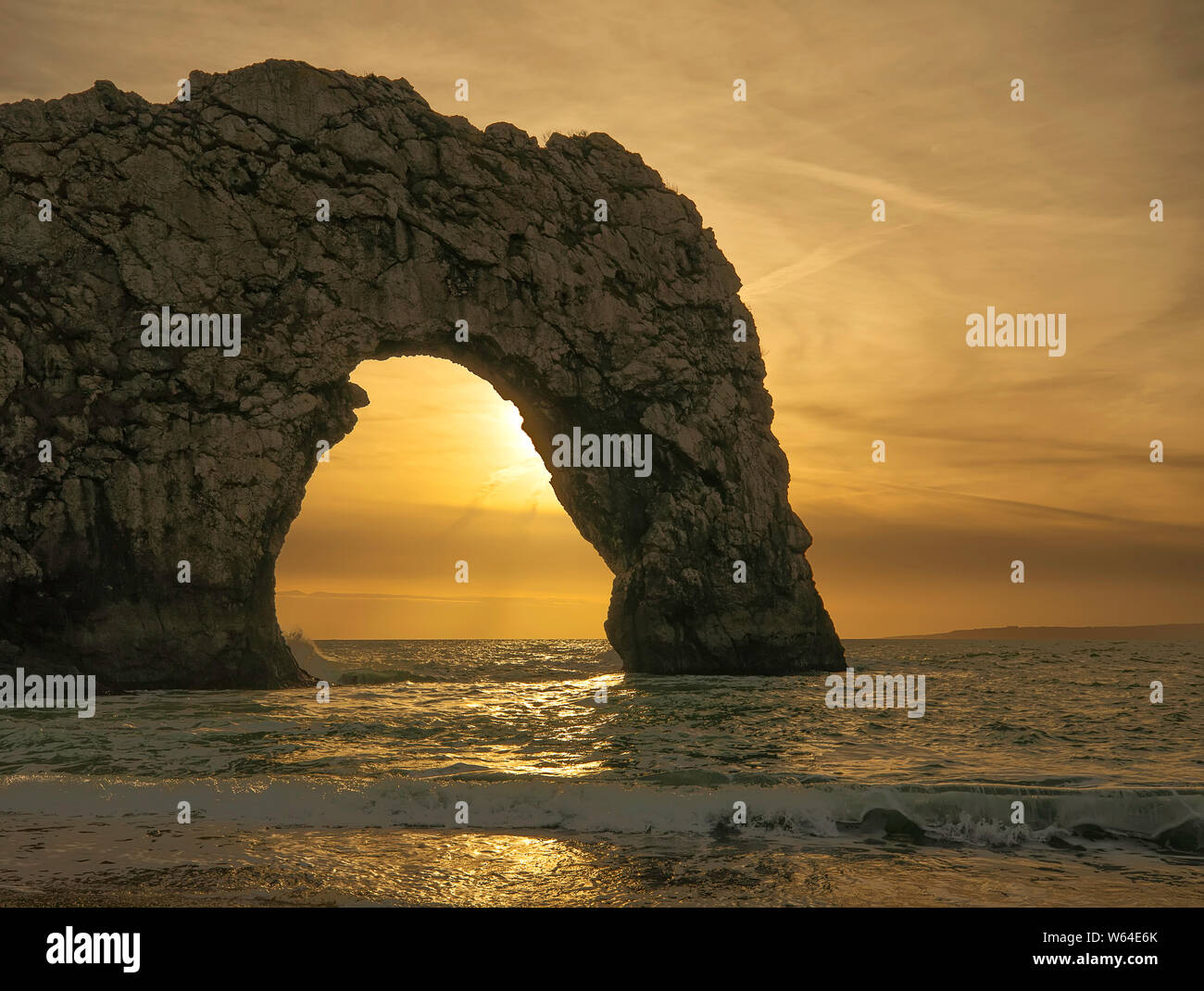 Durdle Door bei Sonnenuntergang. Natürlicher Kalkstein Bogen auf Jurassic Küste von Dorset. Auf der Suche nach Westen in Richtung Portland Bill. West Lulworth. Nordsee. UK. Schließen Stockfoto