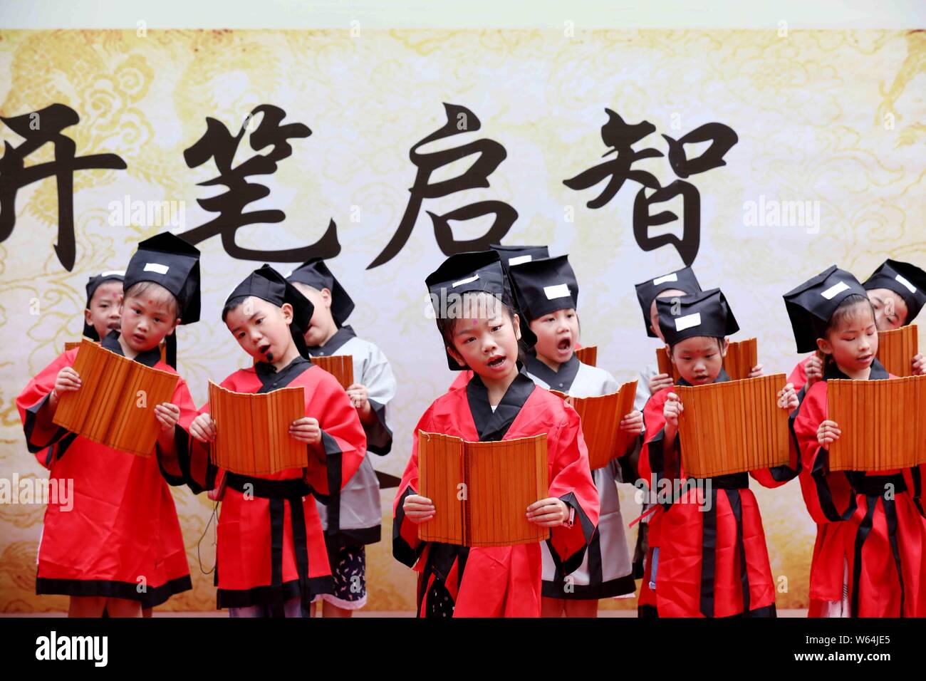 Kinder lesen Klassiker auf Bambus rutscht Im ersten Schreiben Zeremonie ein neues Semester an einer Grundschule in Liuzhou, South China Guangxi Zhuan Stockfoto