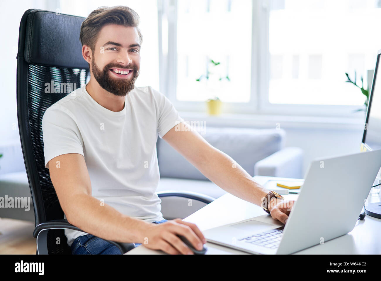 Glückliche Schüler sitzen, Schreibtisch in seinem Zimmer im Wohnheim Stockfoto
