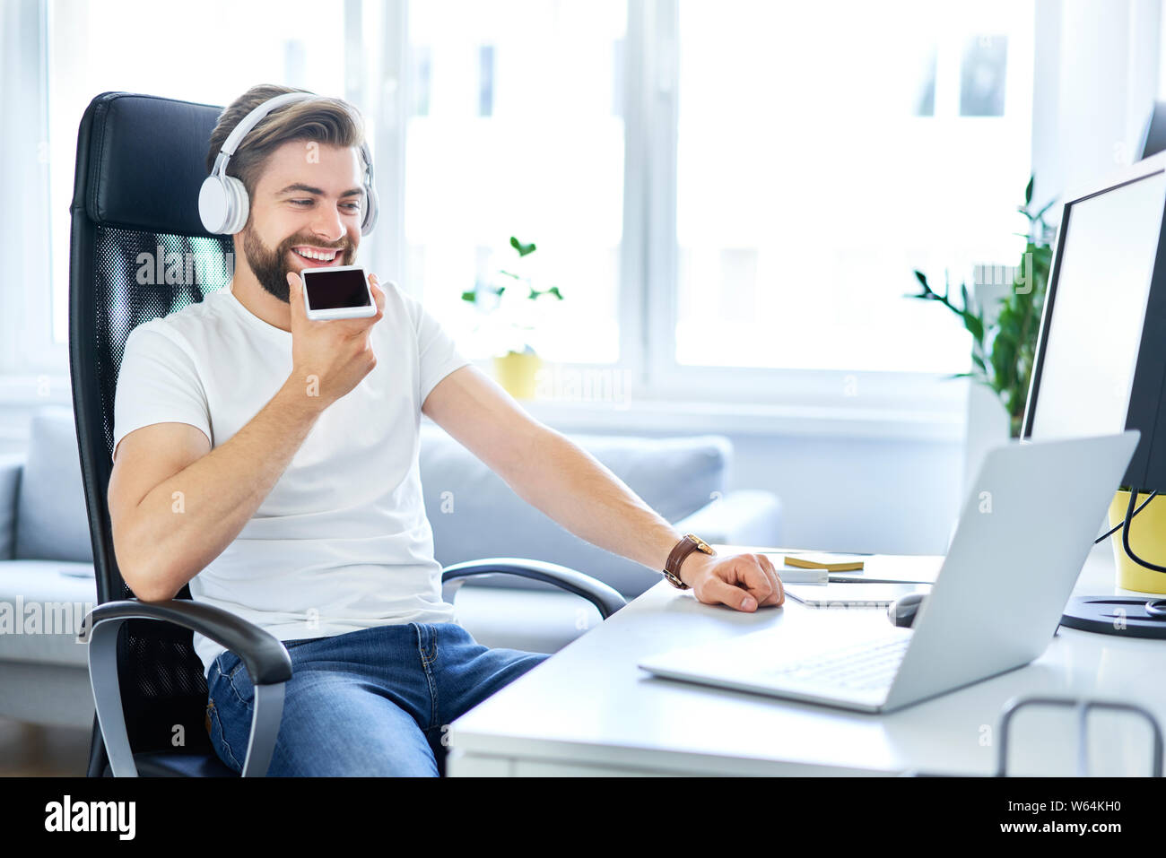 Entspannt Freiberufler vom Schreibtisch Unterhaltung am Telefon sitzen Stockfoto