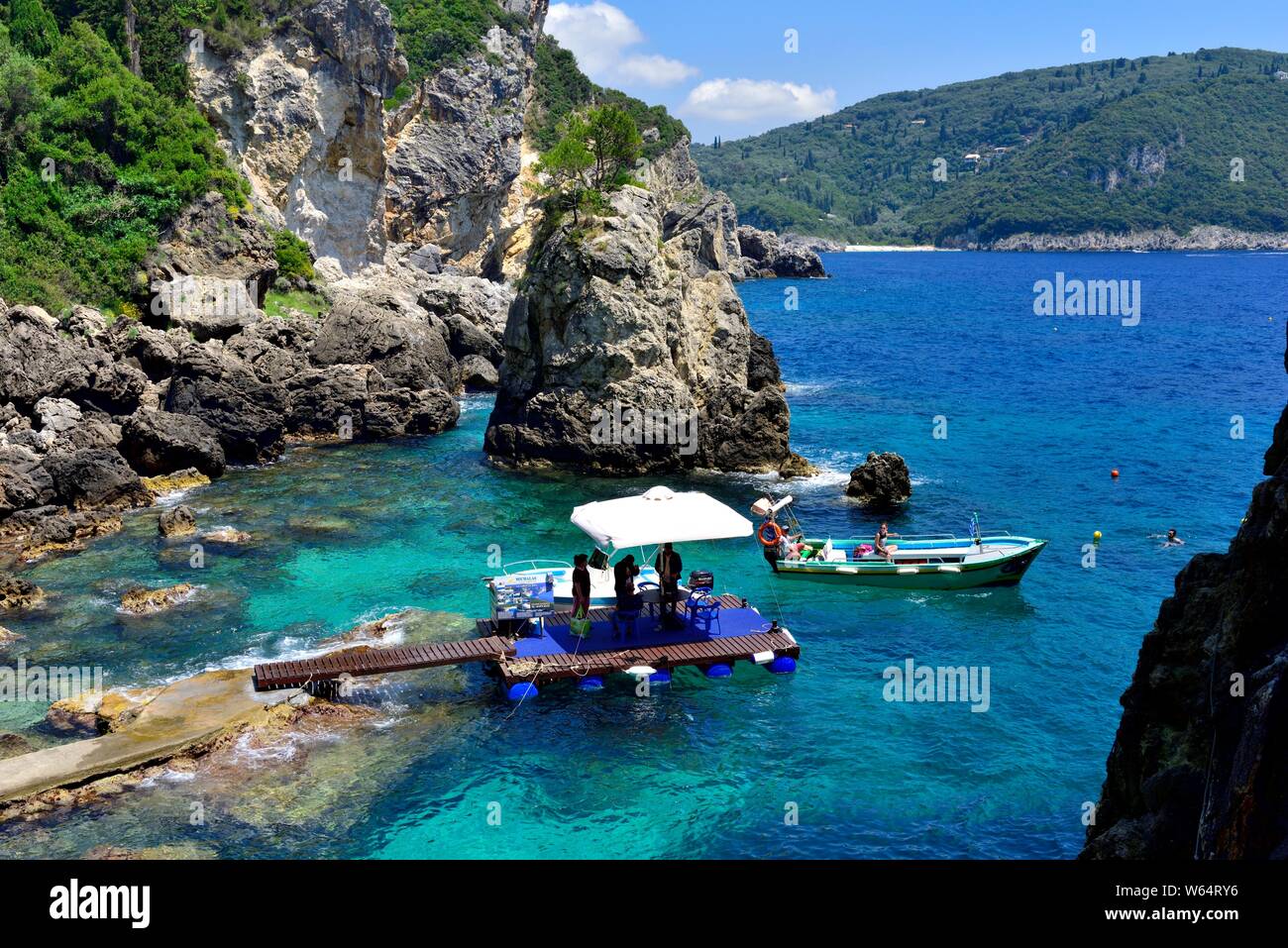Touristenboot Verlassen einer felsigen Bucht, La Grotta Beach Bar, Paleokastritsa, Korfu, Griechenland Stockfoto