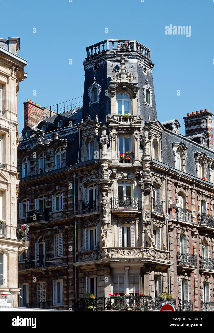 Ecke Apartment Gebäude, verzierte, Statuen, Bügeleisen Balkon Geländer, Fensterläden, Stein, Ziegel, attraktiv, Europa, Normandie, Rouen, Frankreich; Sommer; vertic Stockfoto