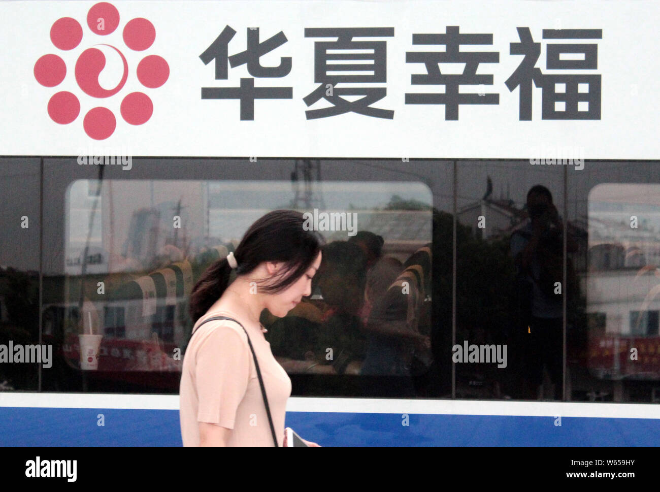 ---- Ein Fahrgast Spaziergänge hinter einem CRH (China Railway High speed) Bullet Train mit einem Logo der China Fortune Land Development (CFLD) in Nanjing city Stockfoto