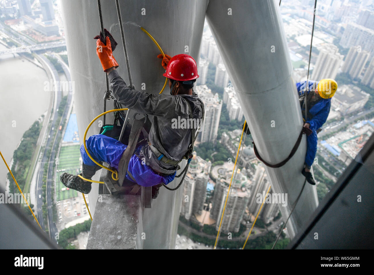 Chinesische Wanderarbeiter aus Seilen Baumeln der Kanton oder Guangzhou Turm Turm während der Gewitter in der Stadt Guangzhou zu reinigen, der South China Guangd Stockfoto