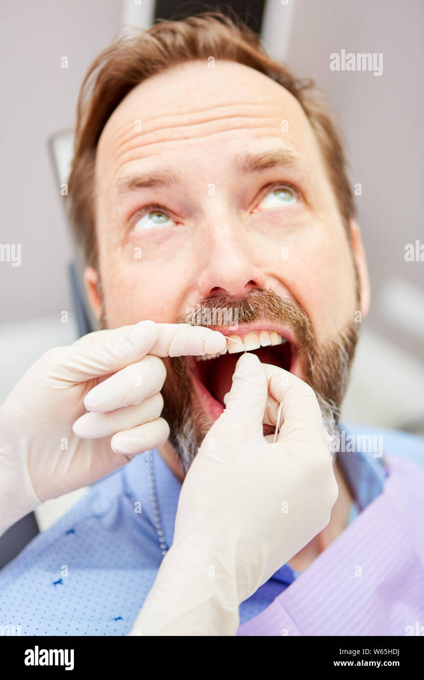 ZFA behandelt Patienten mit Zahnseide in die professionelle Reinigung von Zahnstein Stockfoto