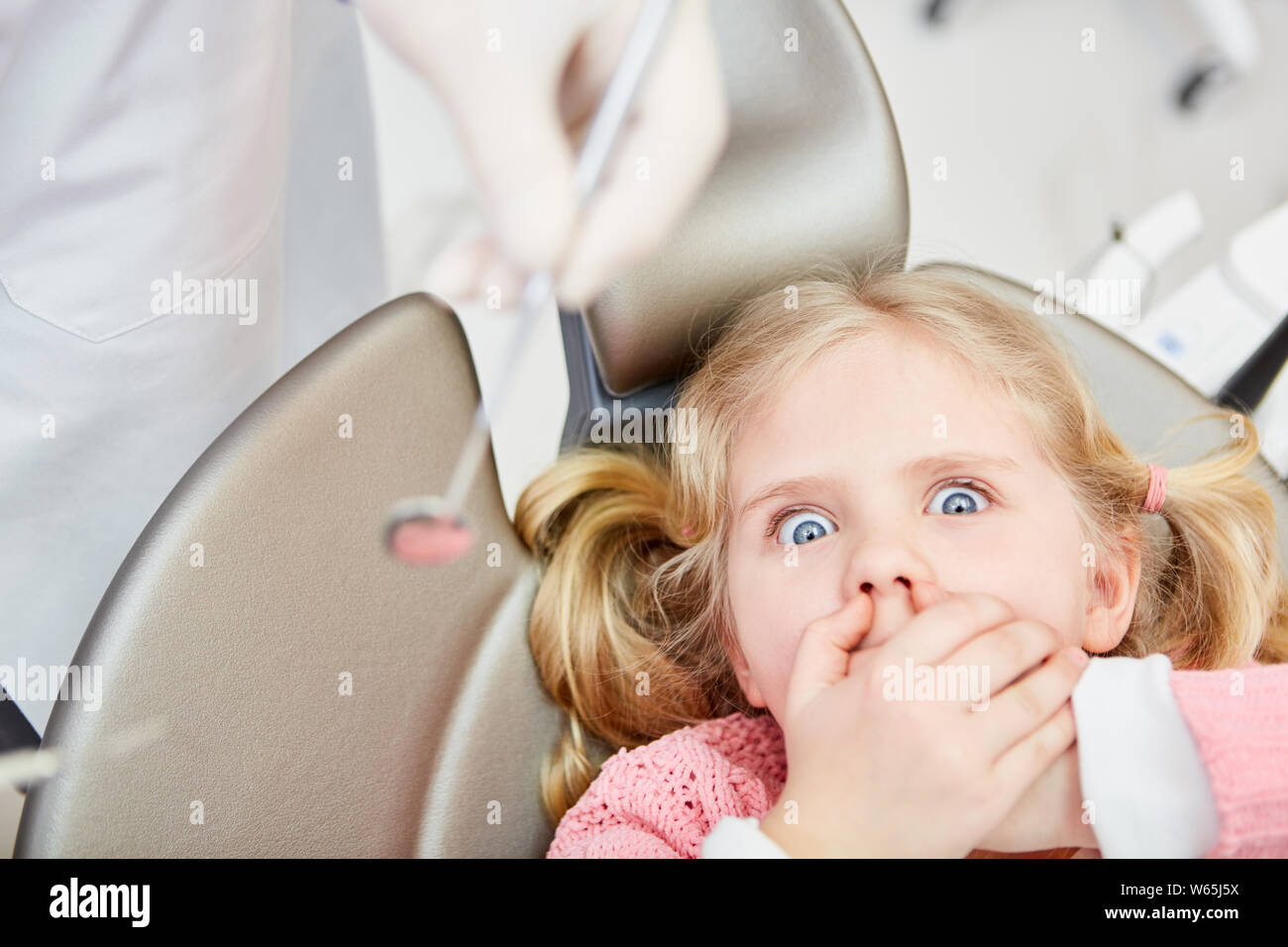 Kleines Mädchen als Angst Patient schaltet ihren Mund, während der Zahnarzt untersuchen Stockfoto