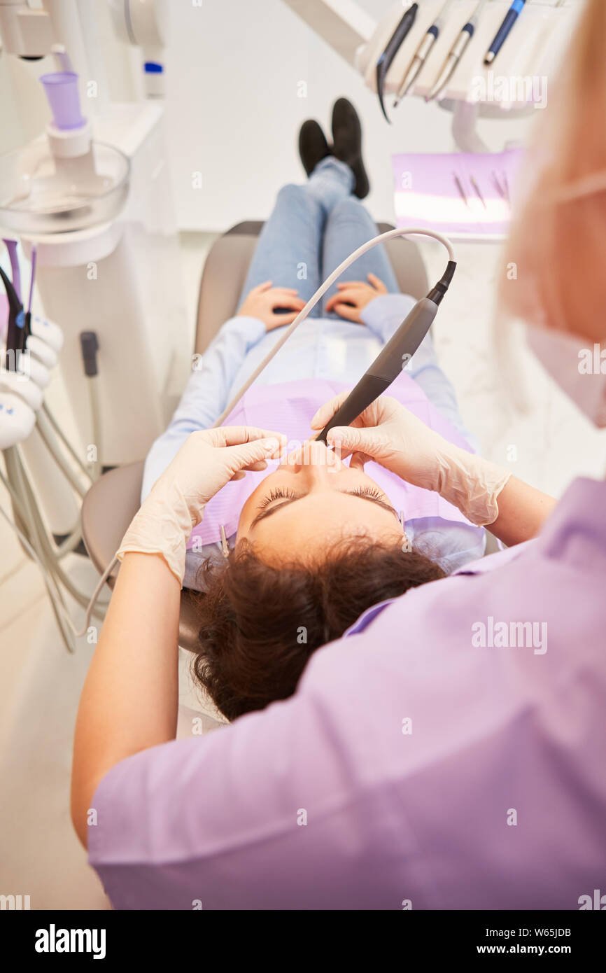 Zahnarzt mit einem Bohrer während einer Wurzelbehandlung in einer Zahnklinik oder zahnmedizinische Praxis Stockfoto