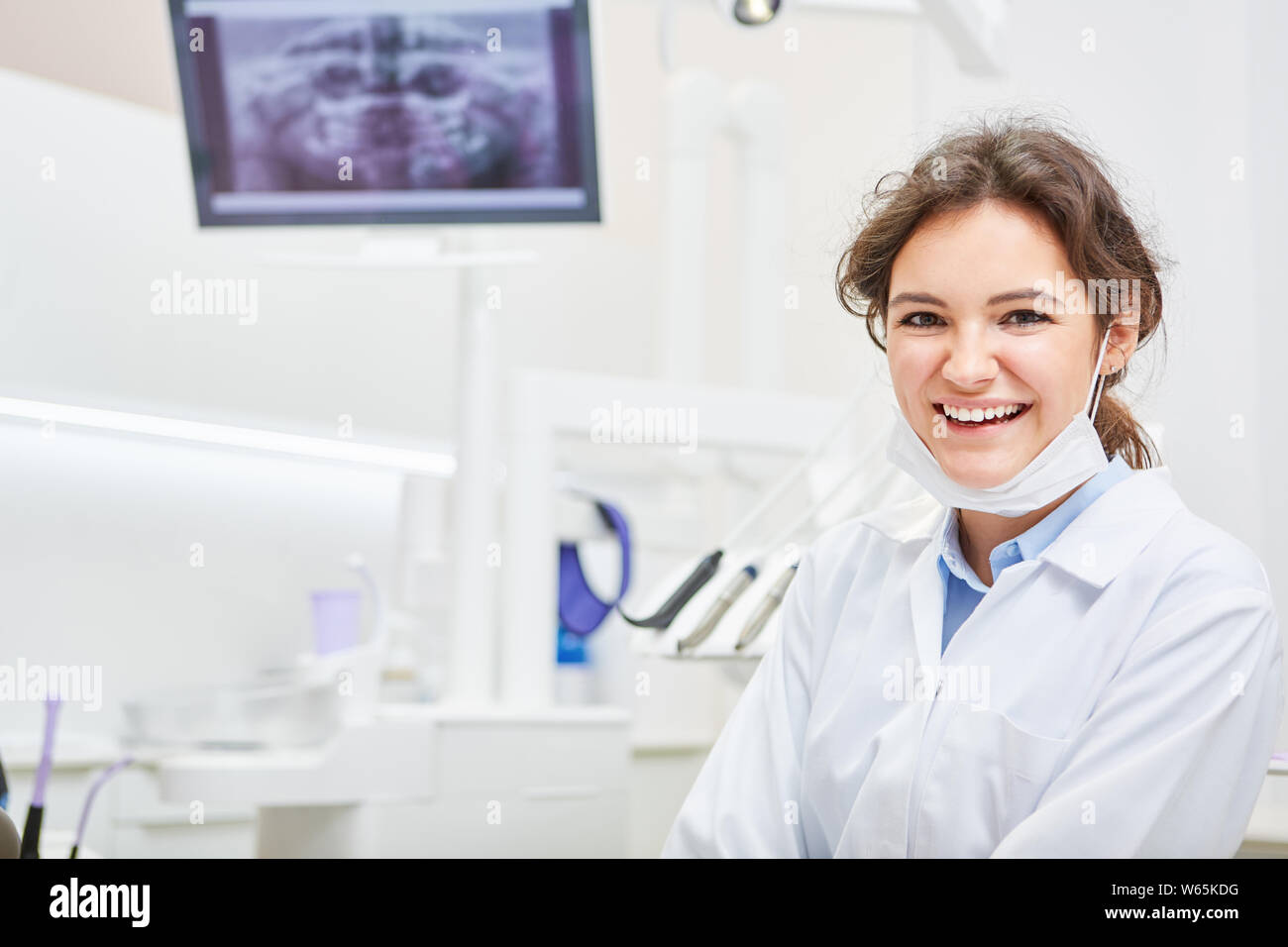 Lächelnde Frau als Zahnarzt oder Zahnarzthelfer in einem zahnmedizinischen Büro Stockfoto