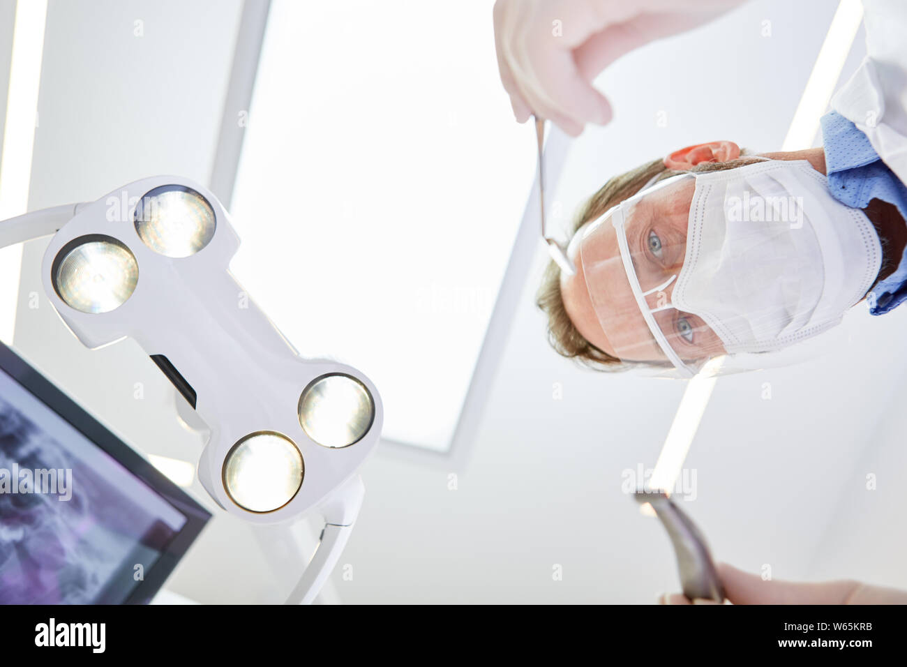 Mundchirurg mit Visier und chirurgische Maske während ein Notbetrieb in einer Zahnklinik Stockfoto