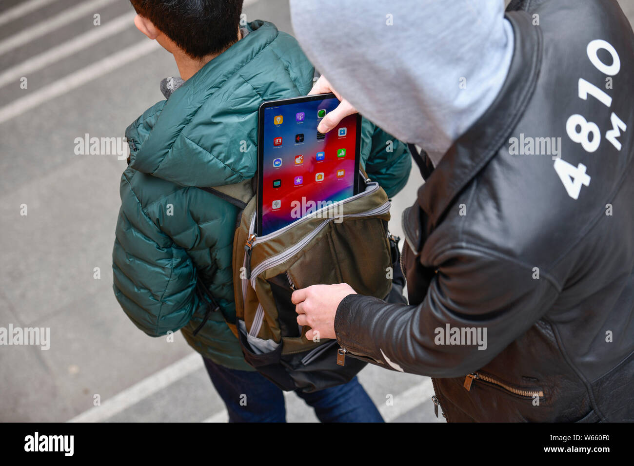 Diebstahl eines Tabletten aus einem Rucksack, Strassenkriminalitaet, Gestelltes Foto Stockfoto