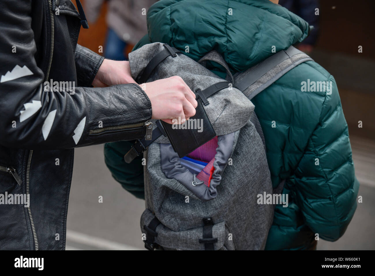 Diebstahl einer Geldboerse aus einem Rucksack, Strassenkriminalitaet, Gestelltes Foto Stockfoto