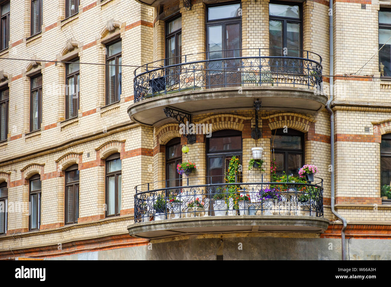 Balkon mit Blumen auf einem Wohngebäude Stockfoto