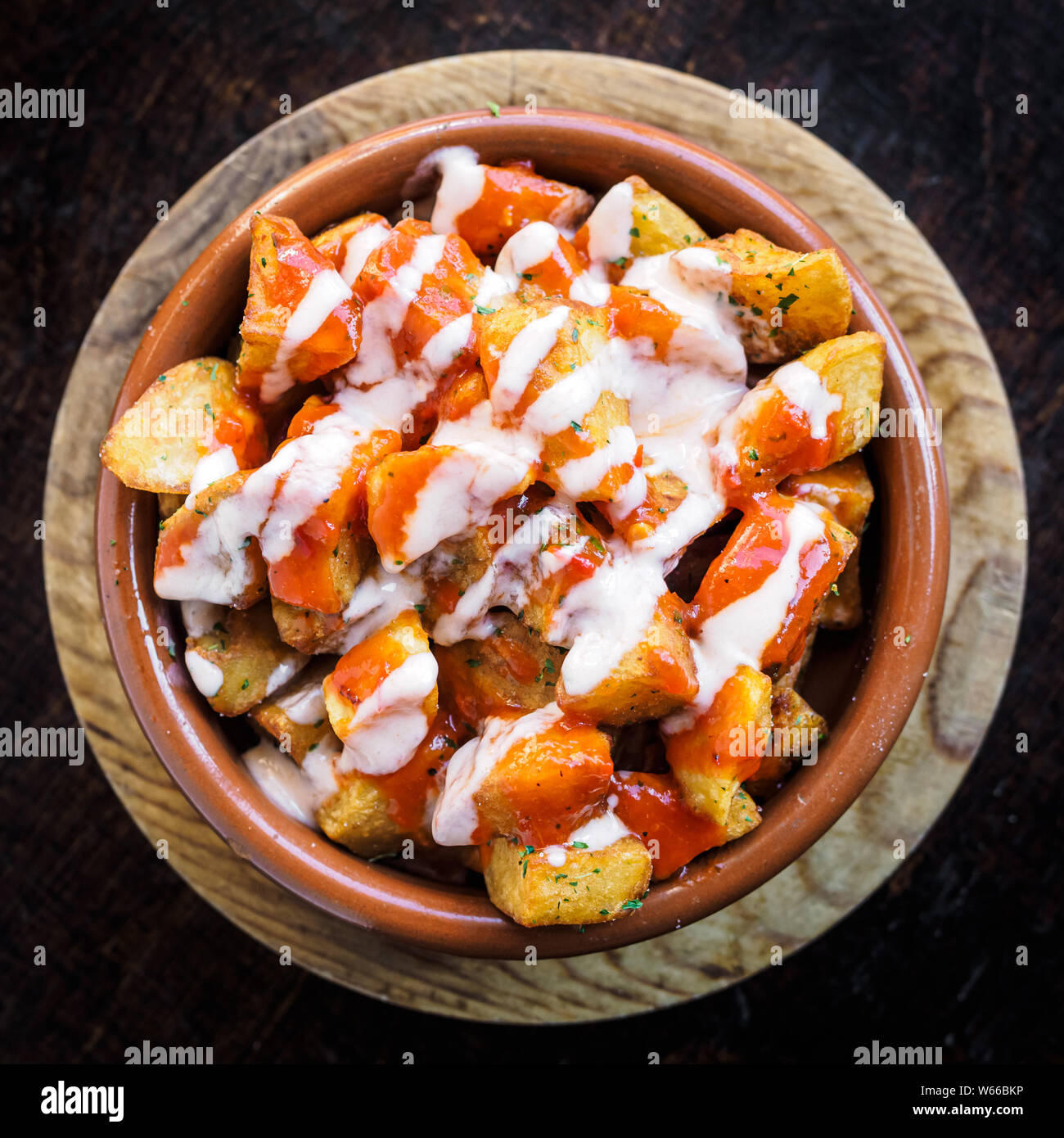 Spanische Kartoffeln Patatas Bravas für Tapas mit Tomaten und würziger Soße auf einer Schüssel Stockfoto
