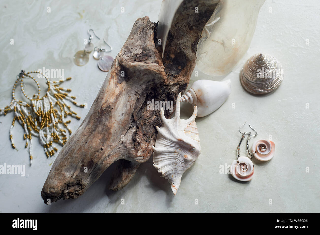 Meer Sammlung auf grauem Marmor Hintergrund. Seashell und Perlmutt Ohrringe. Sommer Schmuck. Stockfoto