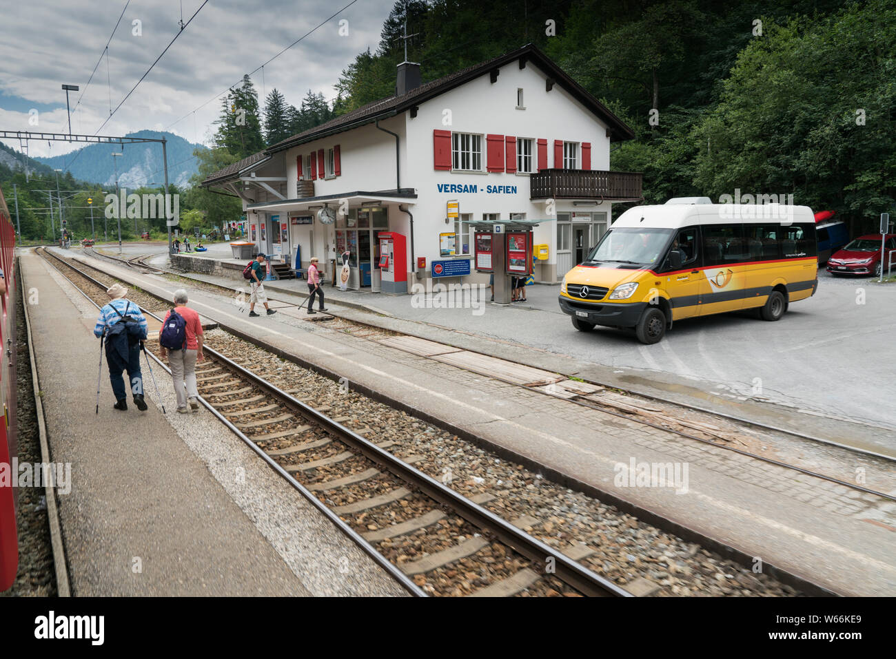 Versam, GR/Schweiz - 30. Juli 2019: öffentliche Bus wartet am Bahnhof in Versam für den Zug zu passieren, während viele Touristen zu Fuß Stockfoto