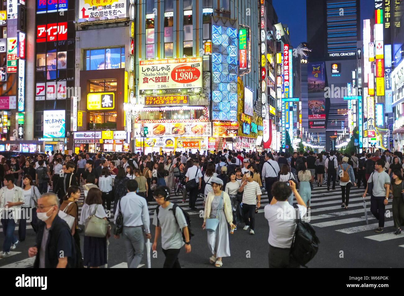 Menschen, die die Straße in Shinjuku, Godzilla Straße, Tokio, Japan, nachts überqueren. Stockfoto