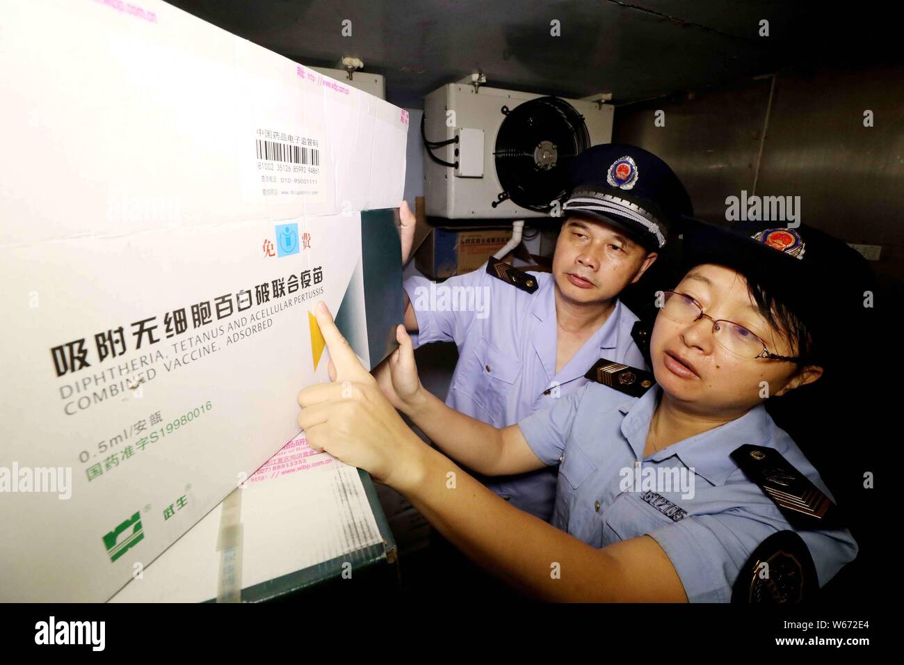 Chinesische Polizeibeamte untersuchen Diphtherie-, Tetanus-, azellulärer Pertussis kombinierte Impfstoffe an der Impfstoff Lager einer Krankheit Steuerung ein Stockfoto