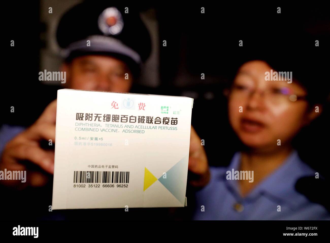 Chinesische Polizeibeamte untersuchen Diphtherie-, Tetanus-, azellulärer Pertussis kombinierte Impfstoffe an der Impfstoff Lager einer Krankheit Steuerung ein Stockfoto
