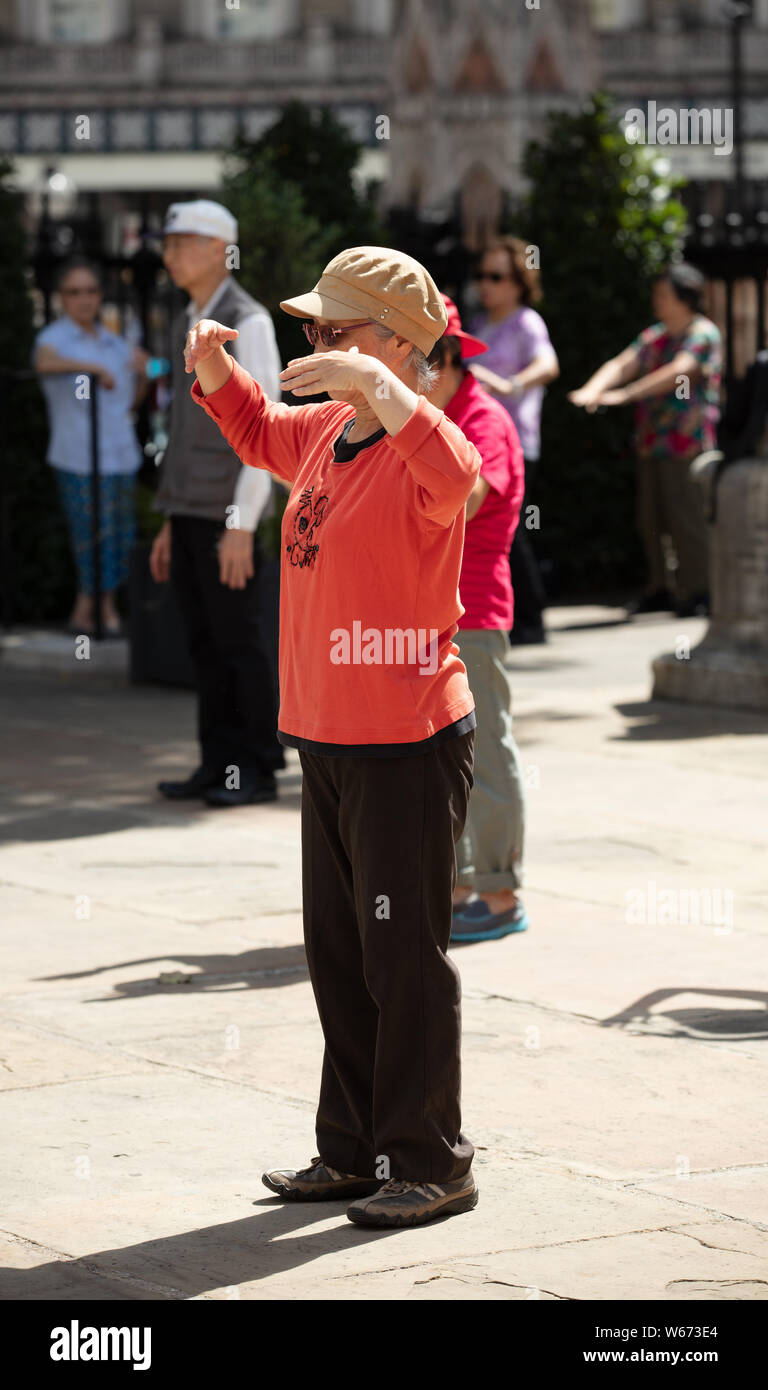 Ältere Praxis die alte Kunst des Tai Chi auf den offenen Raum von St. Martin in den Bereichen Kirche in London an einem Morgen im Juli halten. Stockfoto