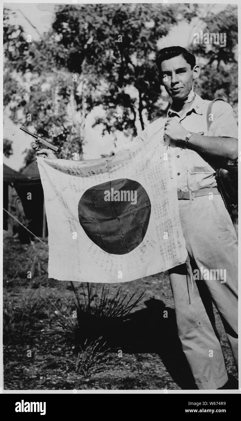 Lt. Woody J. Cochran Holding eine japanische Flagge, Neuguinea, 04/01/1943; Umfang und Inhalt: Ein Cherokee aus Oklahoma und ein bomberpilot, Lieutenant Cochran Silver Star, Purple Heart, Distinguished Flying Cross verdient, und eine Medaille. Stockfoto