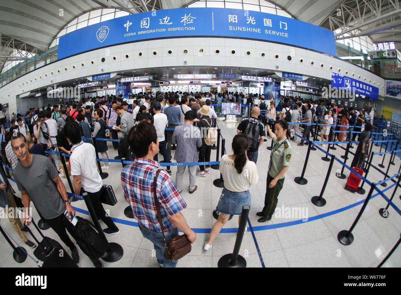 ------ Chinesische Bürger, die im Ausland für Einwanderung Inspektion Warteschlange, die von den Offizieren des Präsidiums der Ausreise und Einreise Administration an der Th zu reisen Stockfoto